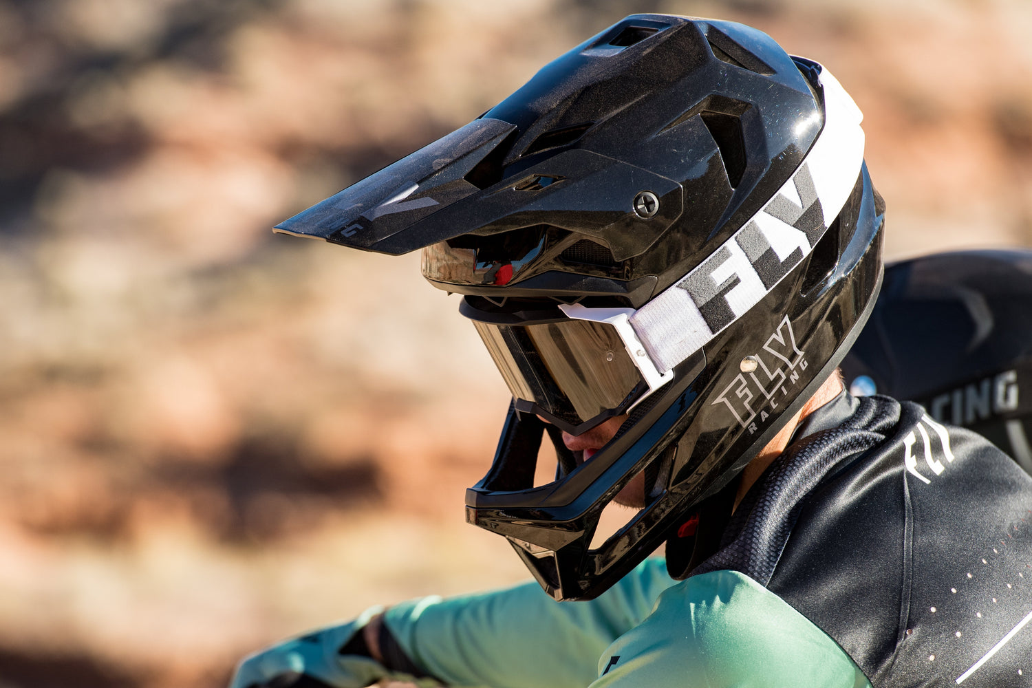Rider wearing a FLY Racing full-face helmet and goggles