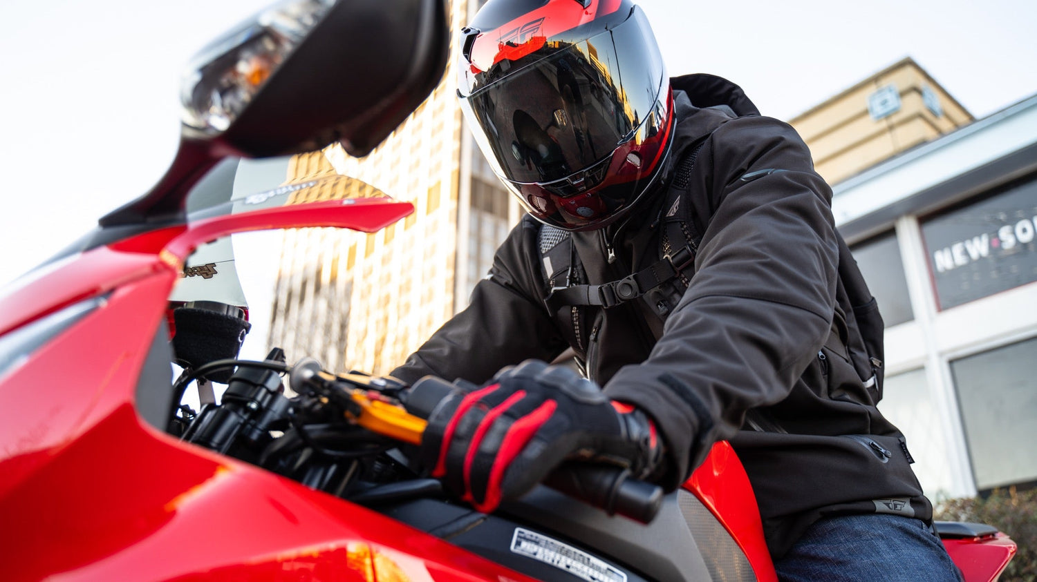 Street motorcycle helmet and gloves on a red bike for eMoto street riding comparison